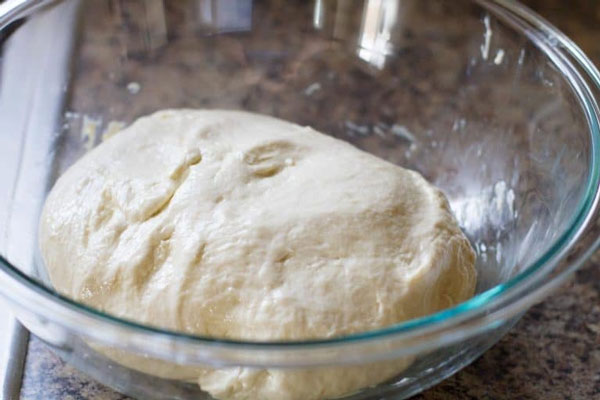 خمیر پیتزا در کاسه چرب شده