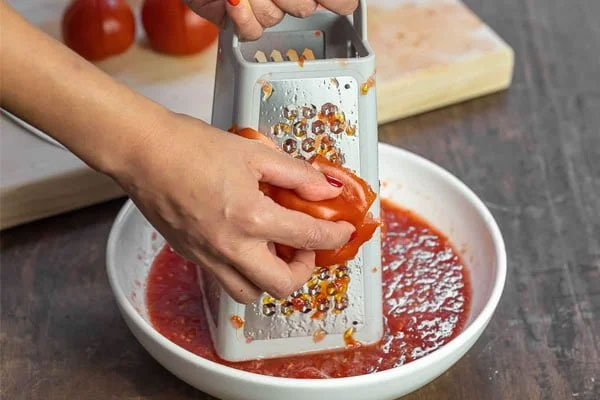 رنده کردن گوجه فرنگی برای تهیه سوپ