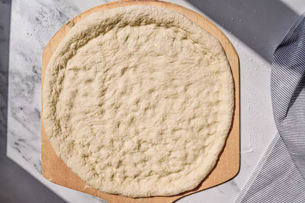 قرار دادن خمیر پیتزا روی قالب