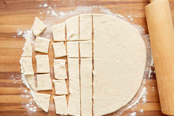 باز کردن خمیر راویولی روی سطح آرد پاشی شده 