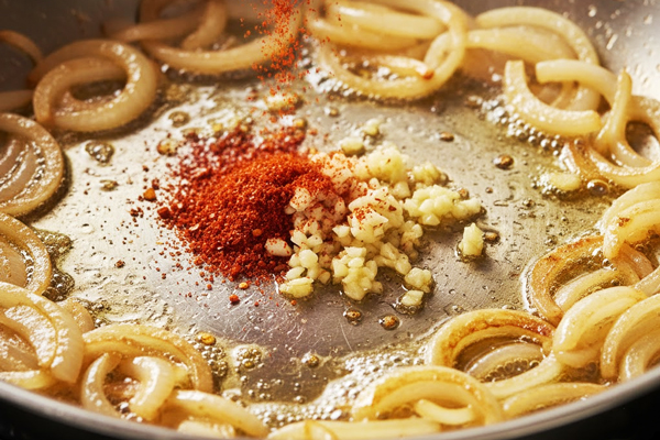 تفت دادن سیر و پودر فلفل قرمز چیلی با پیاز در تهیه پاستا اسفناج