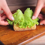 گذاشتن کاهو فرانسوی روی نان تست سوخاری شده