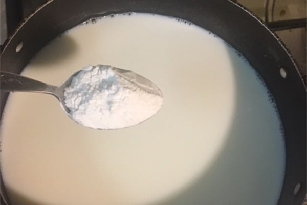 حل کردن آرد گندم در شیر برای تهیه فرنی با آرد گندم