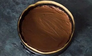 ریختن مواد فیلینگ روی پایه چیز کیک شکلاتی