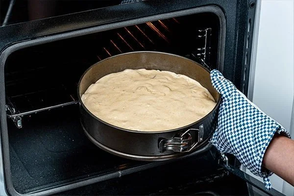 ریختن مایه کیک در قالب و گذاشتن آن در فر برای طرز تهیه کیک اسفنجی ۴ تخم‌مرغی