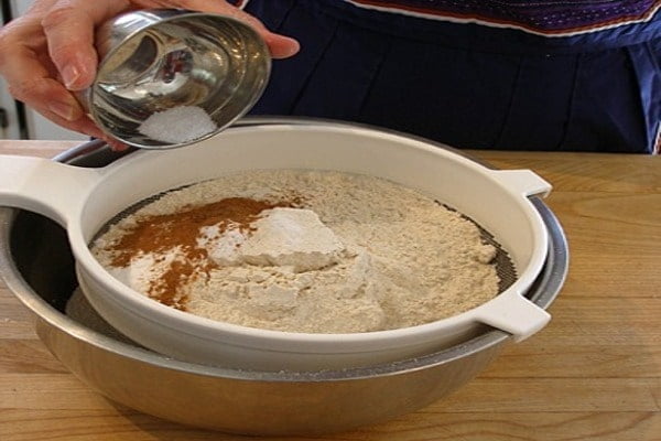 ترکیب کردن آرد، دارچین و جوش‌شیرین برای کیک هویج