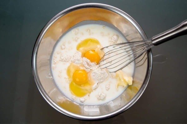 مخلوط کردن باترمیلک، کره و تخم مرغ در طرز تهیه پیراشکی دونات
