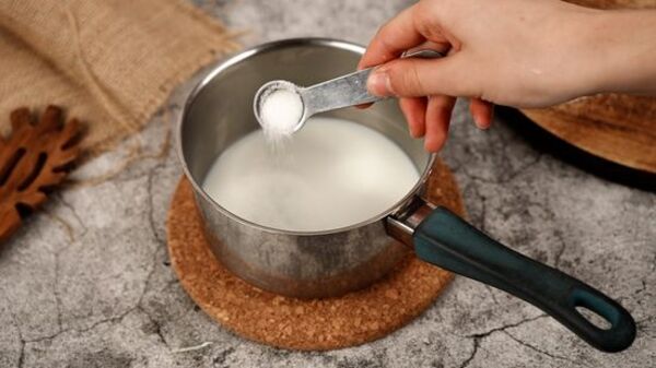 مخلوط کردن شیر، شکر و خمیر مایه در تهیه دونات خانگی