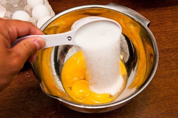 هم زدن زرده تخم مرغ و شکر در تهیه شیرینی