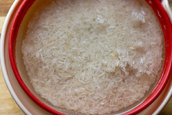 خیساندن برنج برای تهیه زرشک پلو با مرغ مجلسی