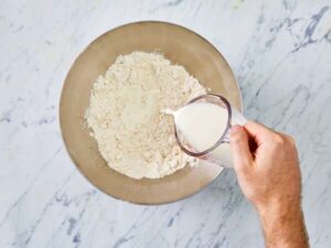مخلوط کردن آرد، نمک و شیر در تهیه کراست