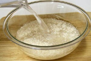 خیساندن برنج برای طرز تهیه عدس پلو با کشمش