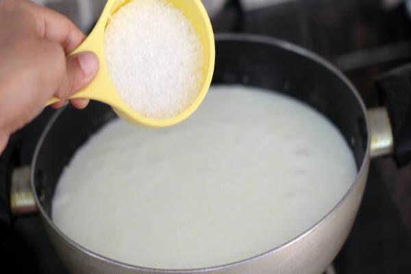 مخلوط کردن شیر و شکر در طرز تهیه خامه کیک