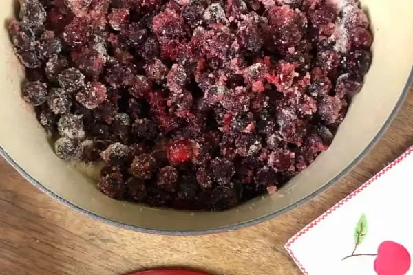 ریختن شکر روی آلبالو برای تهیه مارمالاد آلبالو