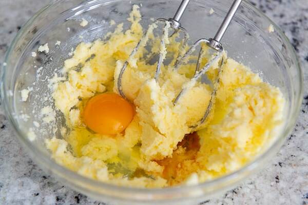 اضافه کردن تخم‌مرغ و وانیل به مخلوط شکر در تهیه دونات