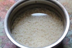 خیساندن برنج برای تهیه دلمه برگ انگور تبریزی