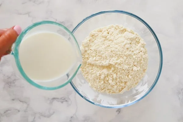 اضافه کردن شیر به بقیه مواد برای درست کردن خمیر دونات