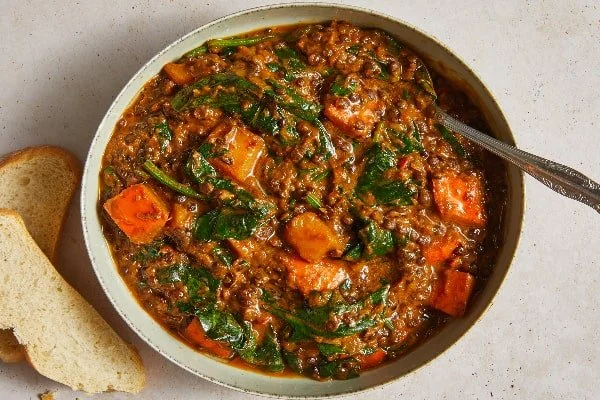 مرحله اضافه کردن اسفناج به خورش کدو حاوایی با مرغ و عدس
