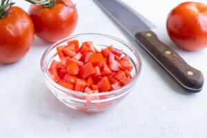 خرد کردن گوجه برای تهیه خوپرش کدو حلوایی و عدس