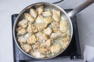 تفت دادن تکه‌های مرغ مزه‌دار شده برای تهیه خورش کدو حلوایی