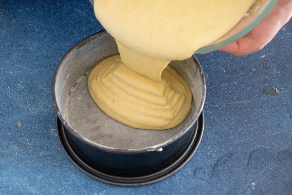 ریختن مایه کیک خیس پرتقالی در قالب کمربندی