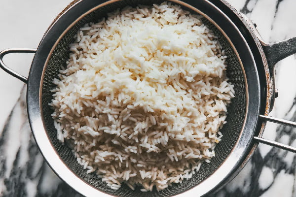قرار دادن آبکش روی قابلمه آب برای پخت برنج فوری