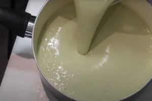 ریختن شیره جوانه گندم در قابلمه برای پخت سمنو
