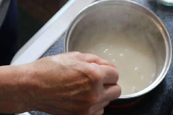 مخلوط کردن آرد برنج و آب برای شله زرد
