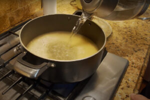 اضافه کردن آب به جو برای پخت سوپ جو