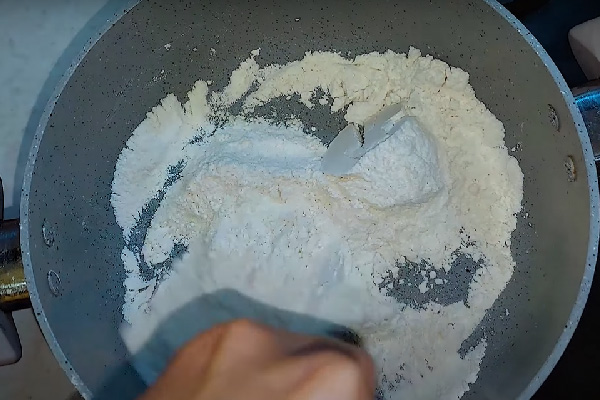 تفت دادن آرد برای تهیه کاچی زعفرانی