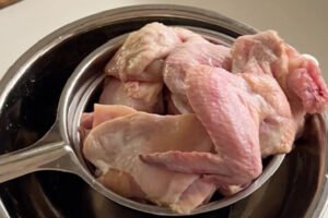 آبکش کردن مرغ مرینیت شده برای تهیه مرغ سوخاری