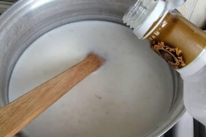 اضافه کردن گلاب به مخلوط مشکوفی در طرز تهیه مشکوفی با شیر