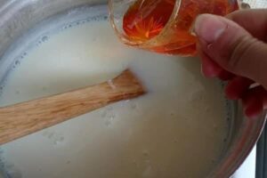 اضافه کردن زعفرون به مخلوط در طرز تهیه مشکوفی با شیر