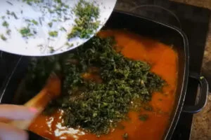 اضافه کردن سبزی آش برای تهیه آش گوجه