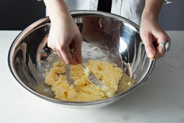 هم زدن کره و پودر قند برای تهیه فراتینگ برای روی کیک ساده بدون فر