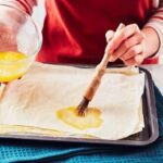 مالیدن کره به ورقه های یوفکا در تهیه شیرینی زبان