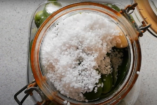 ریختن نمک، سرکه و آب روی خیار برای تهیه خیارشور با آب نجوشیده