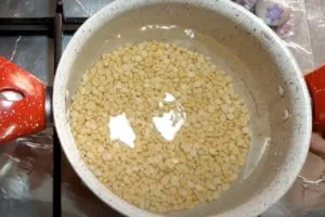 خیساندن لپه برای تهیه خورش کرفس با لپه