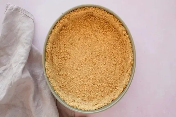 ریختن مخلوط در قالب در طرز تهیه چیز کیک با پنیر خامه ای