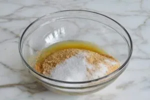 مخلوط کردن شکر، بیسکویت خردشده و کمی نمک برای کراست چیزکیک نیویورکی