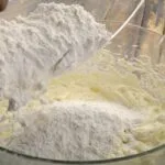 اضافه کردن آرد به مخلوط شیرینی مربایی با پیمانه