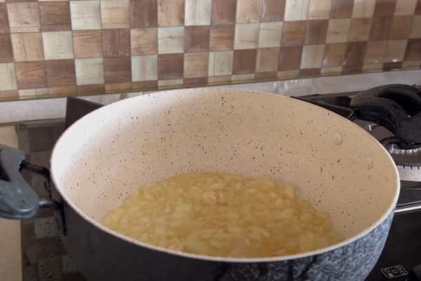 تفت دادن پیاز و اضافه کردن مرغ برای خورشت آلو اسفناج مجلسی با مرغ