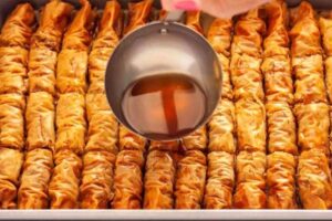 ریختن شربت روی باقلوا رولی