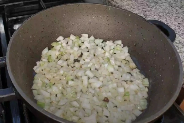 تفت دادن پیاز و سیر برای تهیه دمی گوجه با لوبیا سبز
