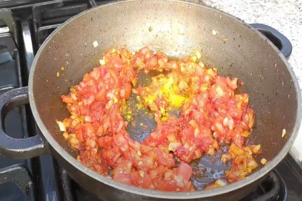 افزودن گوجه‌فرنگی و رب در طرز تهیه دمی گوجه با لوبیا سبز
