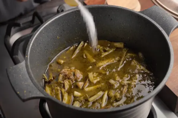 افزودن چاشنی به خورشت کنگر مجلسی
