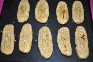 پاشیدن کنجد روی خمیر شیرینی پادرازی
