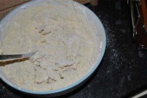 اضافه کردن آرد به مخلوط در تهیه شیرینی پادرازی