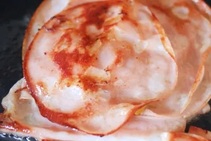 ژامبون سرخ شده در تهیه اسنک کالباس و پنیر گودا