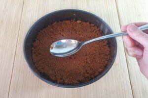 فشردن بیسکوییت در قالب برای تهیه چیزکیک لوتوس